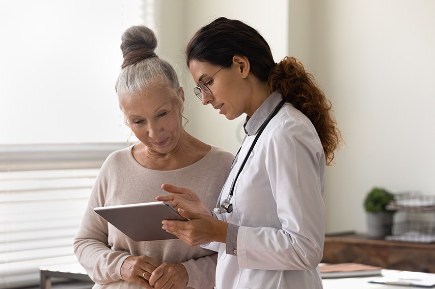 Eine Ärztin zeigt einer Patientin etwas auf dem Tablet