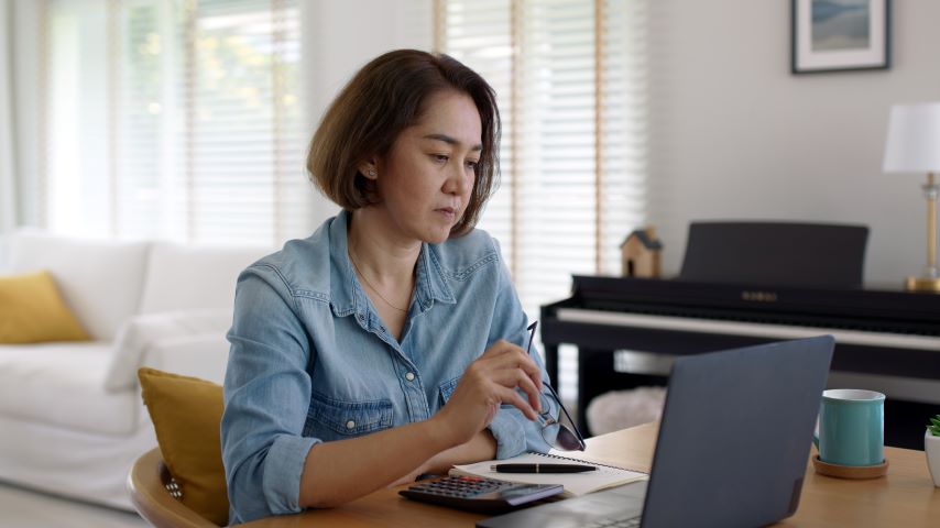 Eine junge Frau sitzt am Laptop.