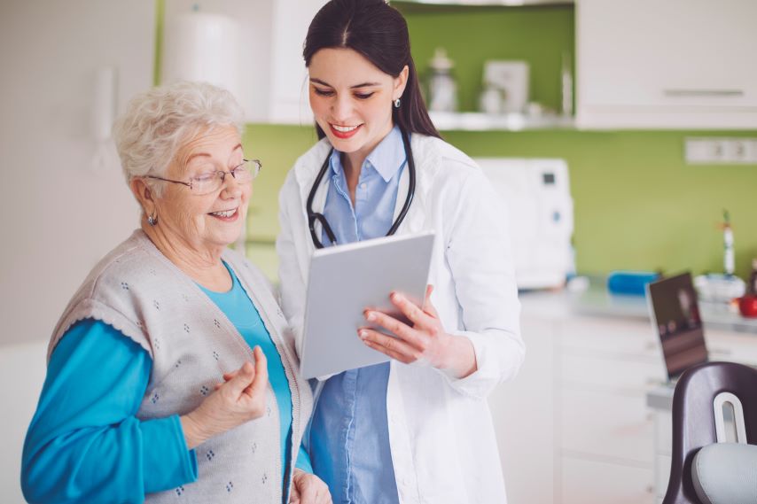 Eine Ärztin erklärt einer älteren Patientin etwas.