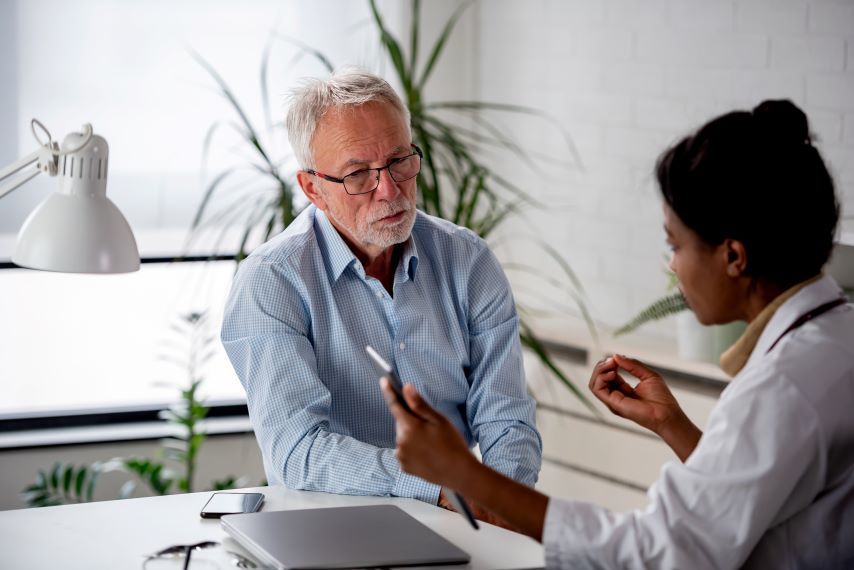 Ein älterer Patient lässt sich über Myelofibrose von einer Ärztin aufklären.